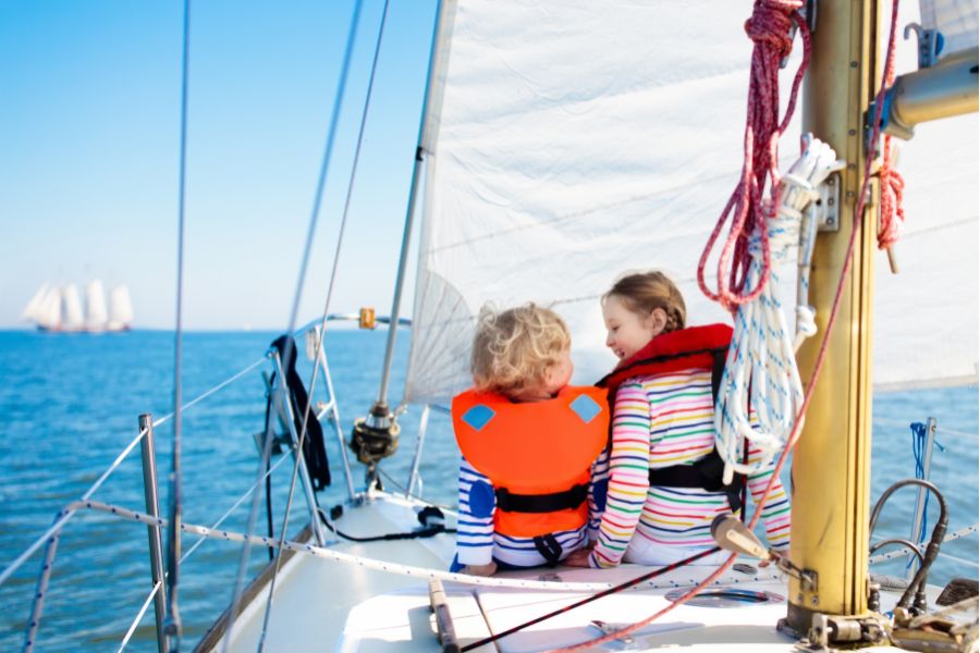 Dos niños pequeños disfrutando de una experiencia surcando el mar abordo de un velero